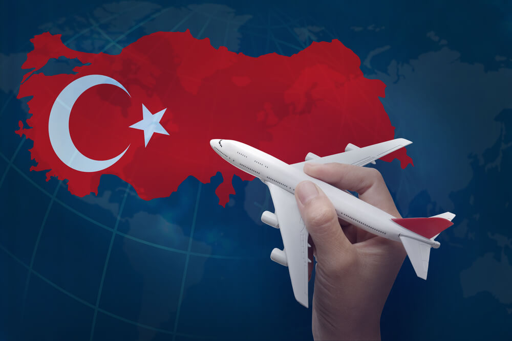 تعبيرية - يد تمسك طائرة فوق خريطة تركيا- نصائح قبل السفر إلى تركيا