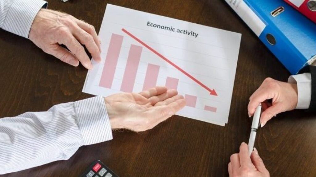 شخص يشير إلى انخفاض مخطط بياني وآخر يمسك ىقلم - طريقة وتكاليف إغلاق شركة في تركيا