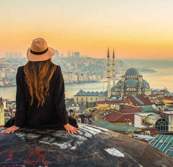 فتاة تجلس في مكان يطل على مدينة اسطنبول - نصائح قبل السفر إلى تركيا